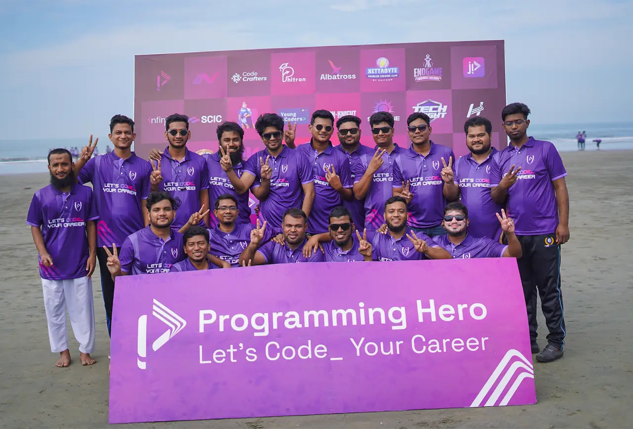 Programming Hero members on the beach behind a Let's Code Your Career banner