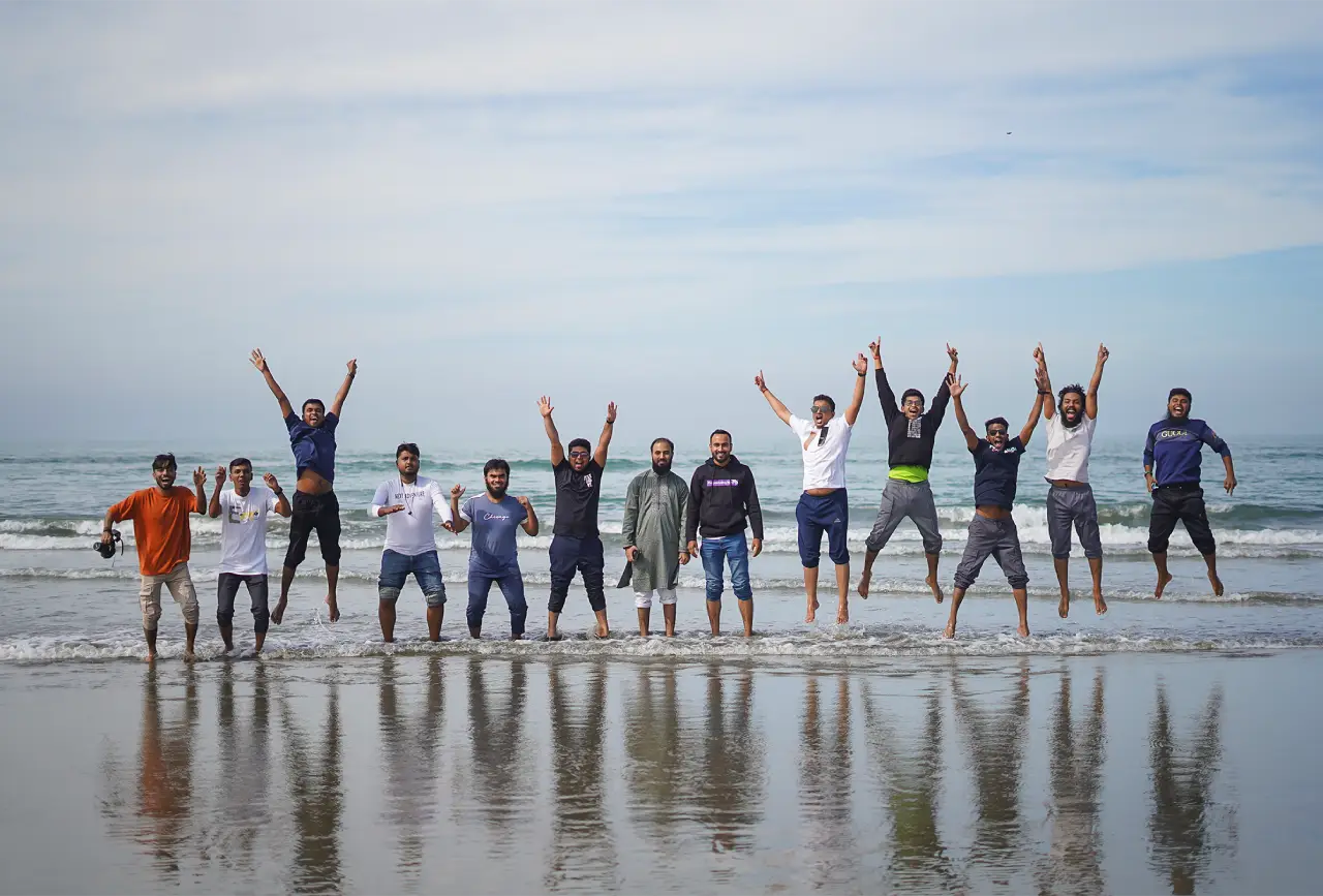 Programming Hero team members jumping together on the beach